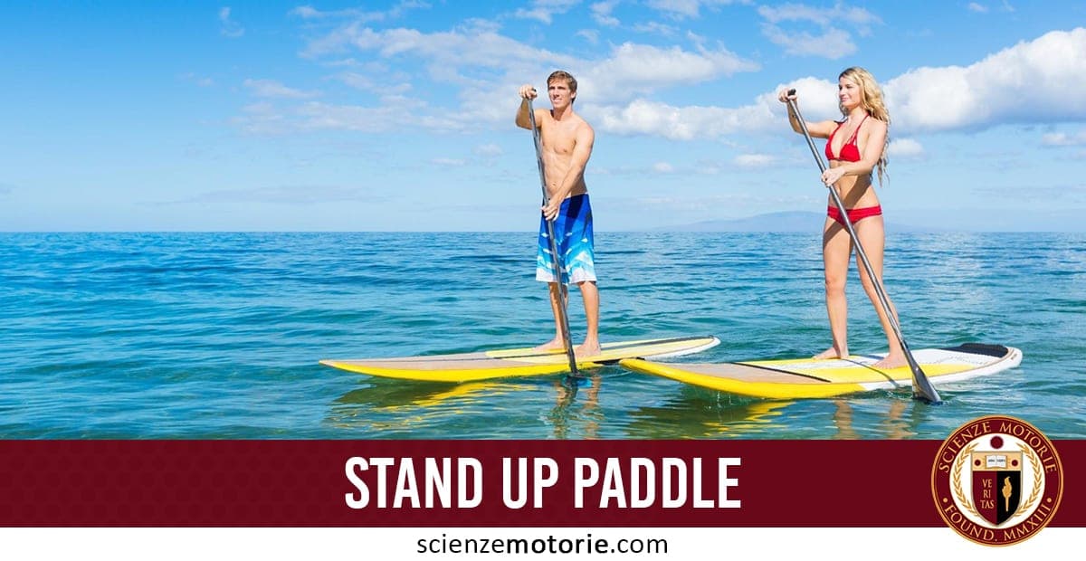 Due persone in piedi su tavole da stand up paddle sul mare sotto un cielo soleggiato, con pantaloncini blu e bikini rosso.